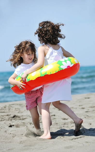 groupe d'enfants heureux sur la plage qui s'amusent et jouent à des jeux