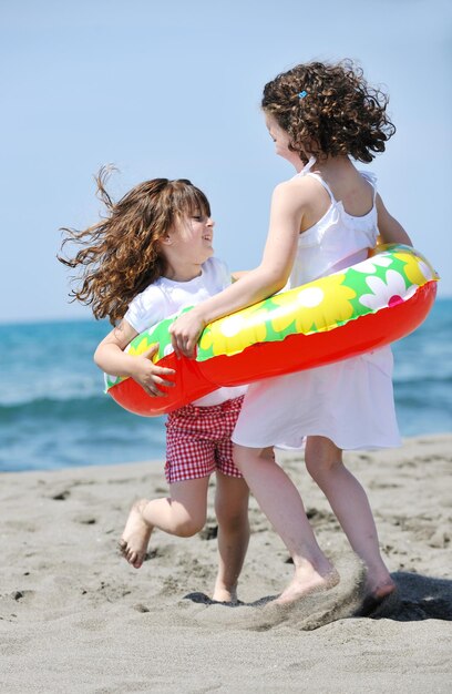 groupe d'enfants heureux sur la plage qui s'amusent et jouent à des jeux