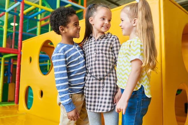 Groupe d'enfants heureux posant dans l'aire de jeux