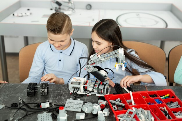 Un Groupe D'enfants Joue Avec Des Robots Assemblés à Partir De Pièces En Plastique.