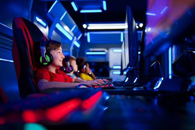 Groupe d'enfants joueurs jouant à des jeux vidéo sur ordinateur dans la salle de jeux