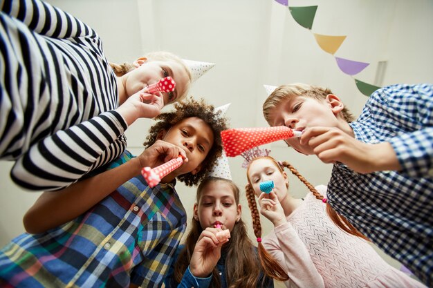 Groupe D'enfants Soufflant Des Cornes De Fête