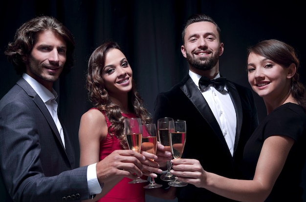 Groupe d'équipe d'affaires heureuse portant un toast au champagne sur fond noir