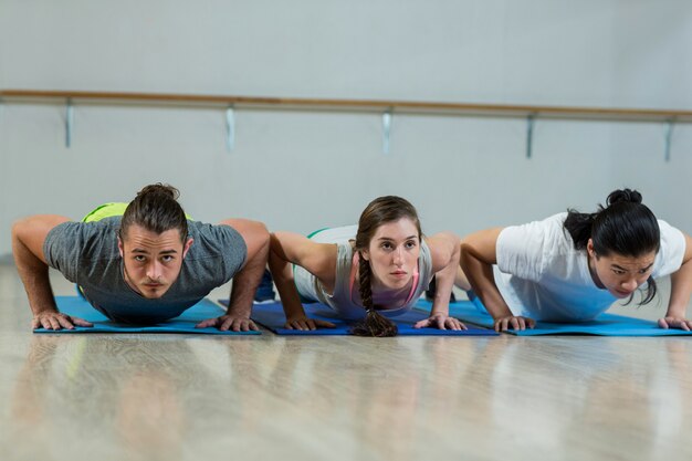 Groupe d'équipe de fitness faisant des pompes