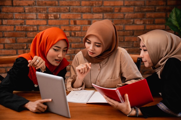 Groupe d'étudiant, amis avec tablette numérique et portant un livre