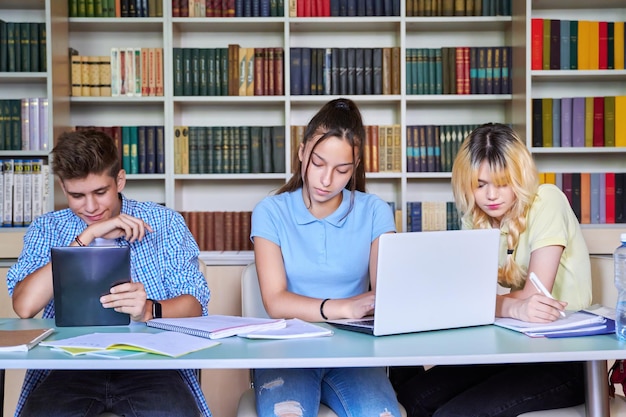 Groupe d'étudiants adolescents étudiant à la bibliothèque de l'école