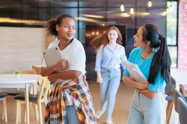 Groupe d'étudiants adolescents marchant pour se pencher dans la bibliothèque de l'école Bibliothèque universitaire concept d'éducation et d'apprentissage des étudiants