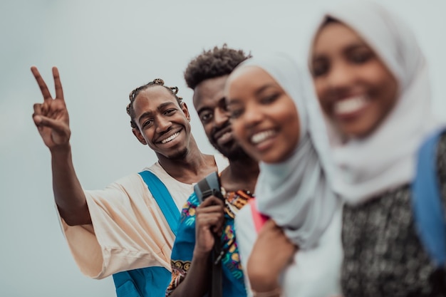 Groupe d'étudiants africains heureux ayant une conversation et une réunion d'équipe travaillant ensemble sur les devoirs des filles portant le hijab musulman traditionnel du Soudan. Photo de haute qualité