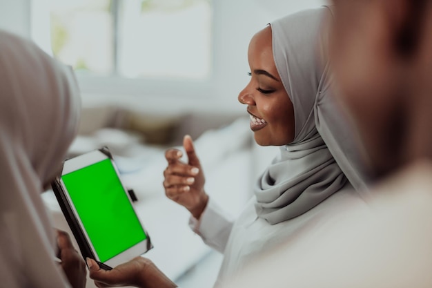 Groupe d'étudiants africains heureux ayant une conversation et une réunion d'équipe travaillant ensemble sur les filles de devoirs portant la mode hijab musulmane traditionnelle du Soudan. Photo de haute qualité