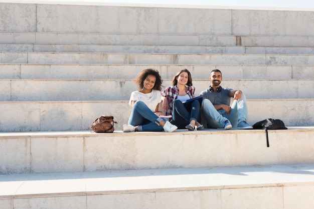 Groupe d'étudiants assis sur les escaliers de l'école