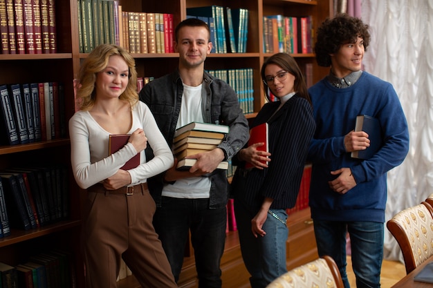 Un groupe d'étudiants chanceux, deux gars et deux femmes dans la bibliothèque après l'examen