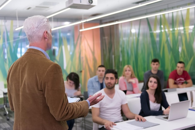 un groupe d'étudiants étudie avec un professeur dans une salle de classe moderne