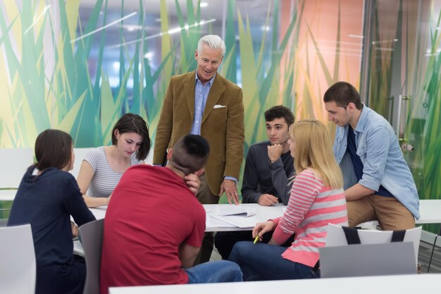 un groupe d'étudiants étudie avec un professeur dans une salle de classe moderne