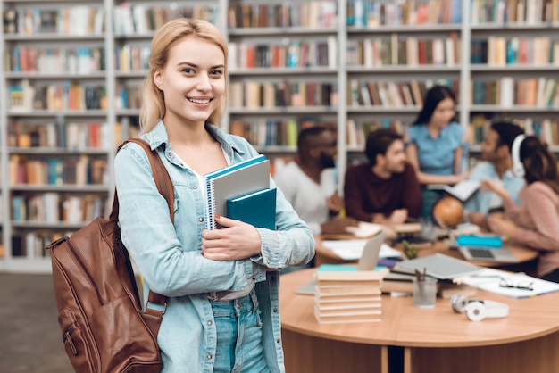 Groupe d'étudiants multiculturels ethniques assis dans la bibliothèque.