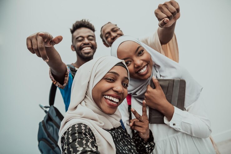 Un groupe d'étudiants multiethniques prend un selfie avec un smartphone sur fond blanc. Mise au point sélective. Photo de haute qualité