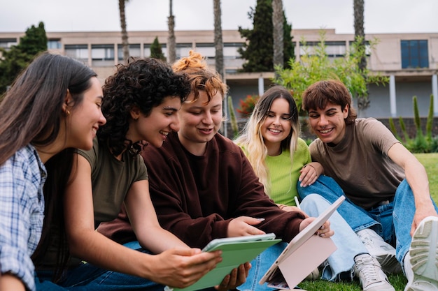 Groupe d'étudiants prenant des photos sur l'herbe du campus