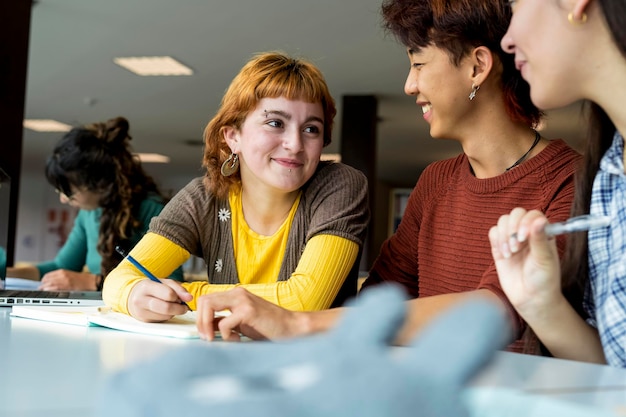 Groupe d'étudiants qui étudient ensemble dans une bibliothèque