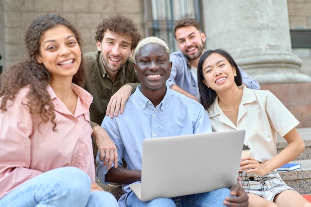 Photo groupe d'étudiants regardant une vidéo amusante sur un ordinateur portable