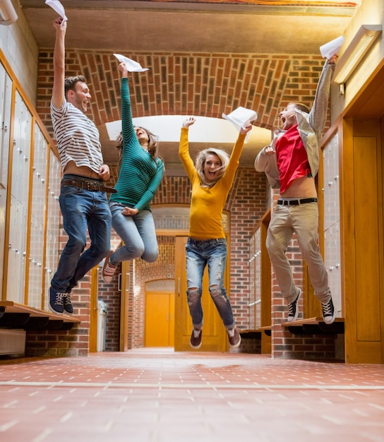 Groupe d&#39;étudiants sautant dans le couloir du collège