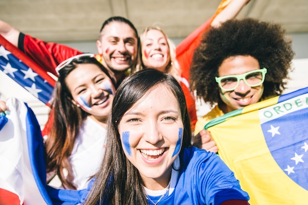 Groupe de fans de football mixtes prenant selfie