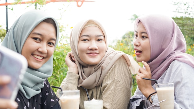 Groupe de femme asiatique hijab selfie dans un café avec un ami