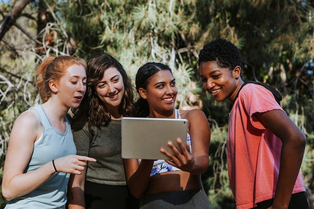 Groupe de femmes actives à la recherche d&#39;une tablette numérique