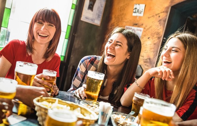 Groupe de femmes copines heureuses buvant de la bière au restaurant-bar-brasserie