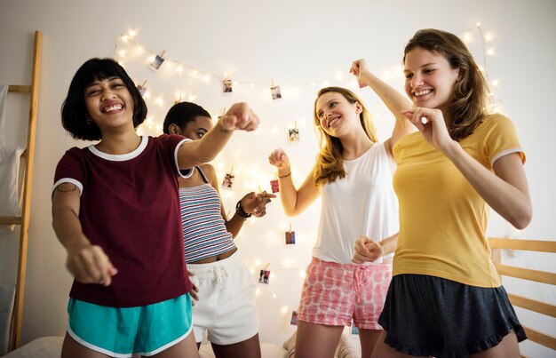 Groupe de femmes diverses s&#39;amusant sur le lit ensemble