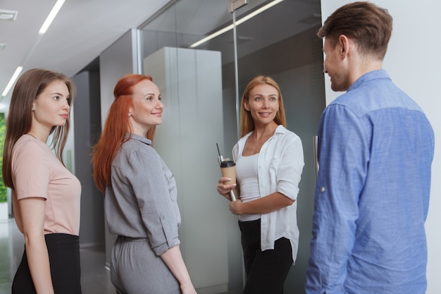 Groupe de femmes entrepreneurs parlant à leur collègue masculin