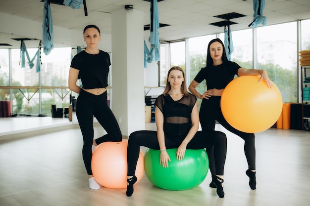 Groupe de femmes faisant des exercices d'étirement avec un ballon de fitness pendant l'entraînement Pilates Photo de haute qualité