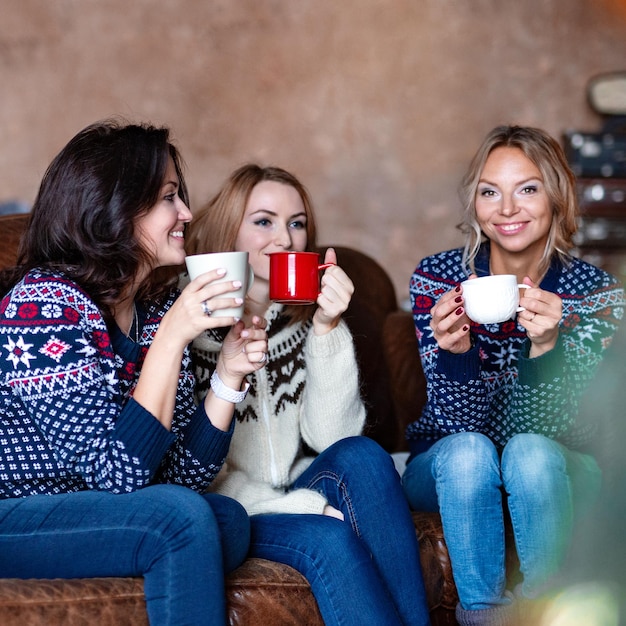Groupe de femmes heureuses discutant en buvant du café à la maison