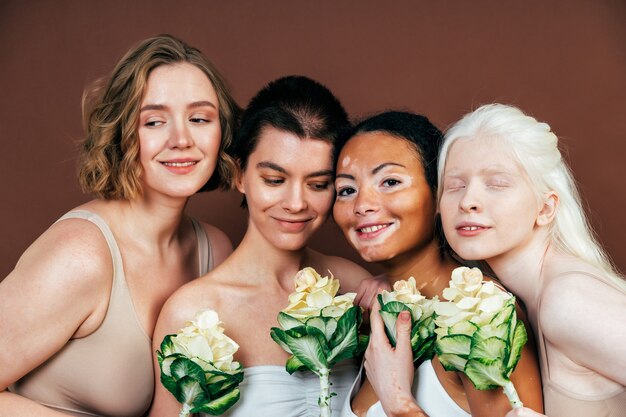 Groupe de femmes multiethniques avec différents types de peau posant ensemble en studio. Concept sur la positivité corporelle et l'acceptation de soi