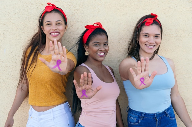 Groupe de femmes multiethniques montrant leurs mains avec un ruban rose dessinant la sensibilisation au cancer du sein Symbole international du cancer du sein Concept de la journée internationale des femmes et de la journée mondiale contre le cancer