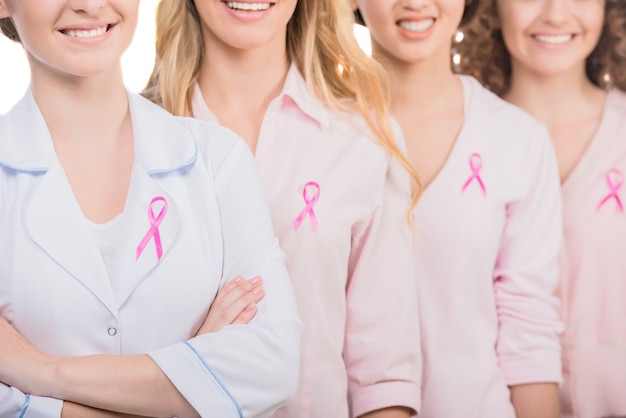 Groupe de femmes souriantes et médecin en t-shirts blancs.