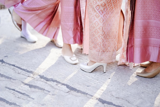 Groupe de femmes thaïlandaises portant un sarong rose avec des talons hauts Choisissez de vous concentrer sur les chaussures