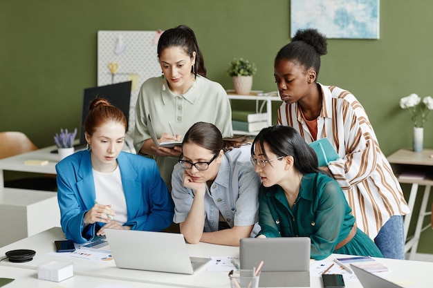 Groupe de femmes utilisant un ordinateur portable au travail