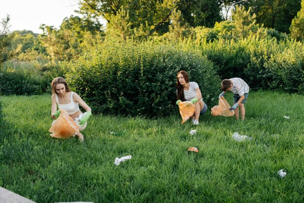 Un Groupe De Filles Avec Des Enfants Au Coucher Du Soleil S'occupe De La Collecte Des Ordures Dans Le Parc Recyclage Des Soins Environnementaux