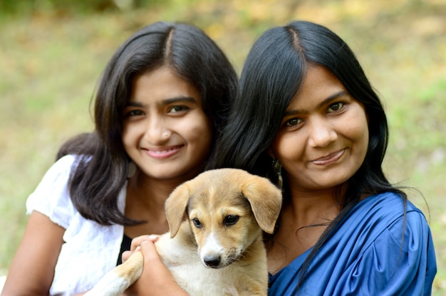 Groupe de filles jouent avec un chiot dans le parc en plein air