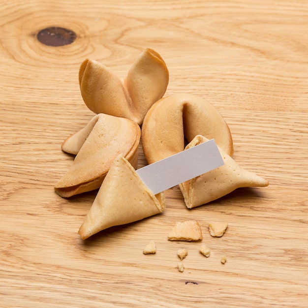 Un groupe de fortune cookies avec une note de message sur fond de table en bois. Pris en studio avec une marque 5D III.