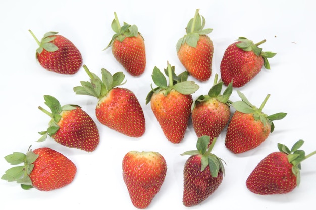 Un groupe de fraises sont sur un fond blanc.