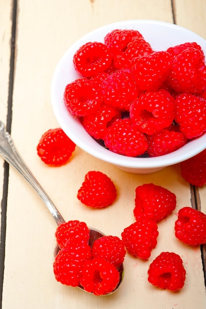 Groupe de framboise fraîche sur une cuvette et une table blanche