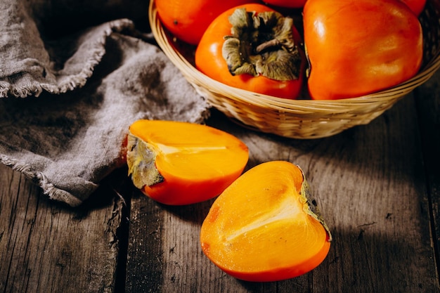 Un groupe de fruits de kaki orange mûrs Fruits de kaki sur fond rustique de planche de bois