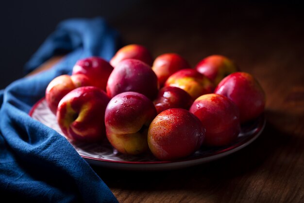 Un groupe de fruits ou de pêches nectarines colorées sur une plaque