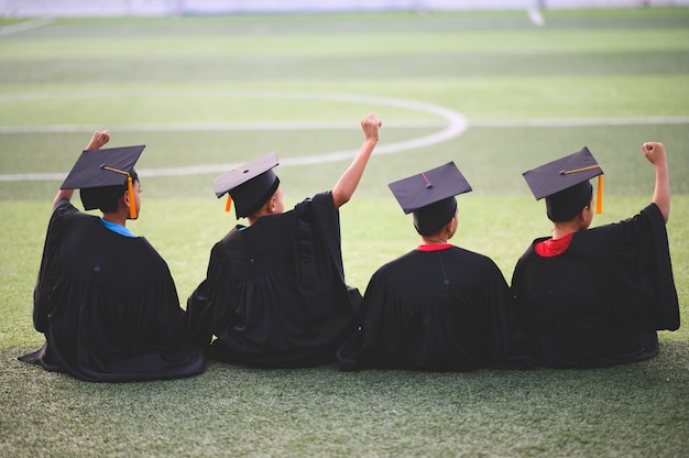 Un groupe de garçons est heureux le jour de la remise des diplômes à l'école