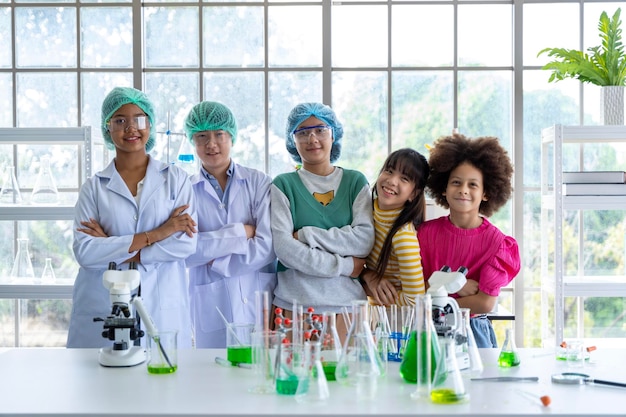 Photo un groupe de garçons et de filles qui aiment la science s'amusent à faire des expériences dans le laboratoire de l'école.