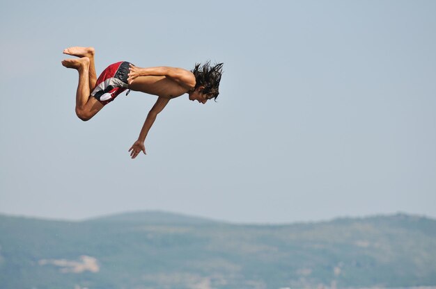 groupe de garçons happyfriend s'amuser et sauter en mer pendant les vacances d'été