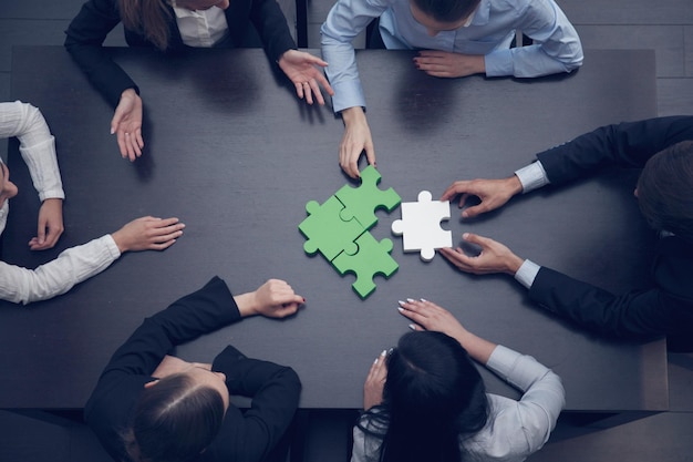 Photo groupe de gens d'affaires assemblant le concept de soutien et d'aide de l'équipe de puzzle