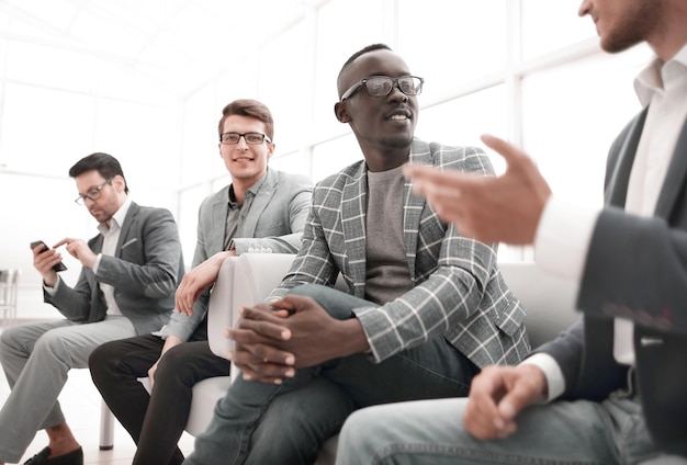 Groupe de gens d'affaires assis dans le couloir du bureau