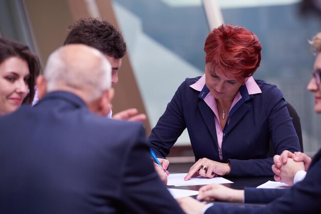 un groupe de gens d'affaires en démarrage se réunit dans un intérieur de bureau moderne et lumineux, des investisseurs seniors et de jeunes développeurs de logiciels signent un contrat