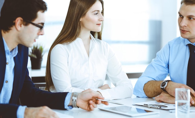 Groupe de gens d'affaires discutant de questions lors d'une réunion dans un bureau moderne. Gestionnaires à la négociation ou au remue-méninges. Travail d'équipe, partenariat et concept d'entreprise